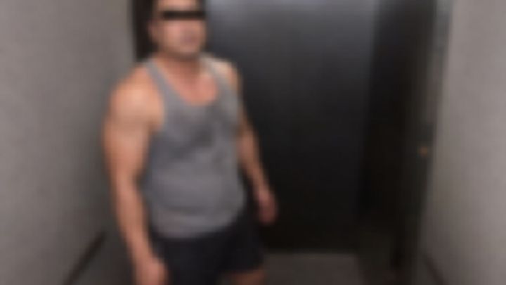 エレベーターに乗るタンクトップ姿のガタイのいい男性