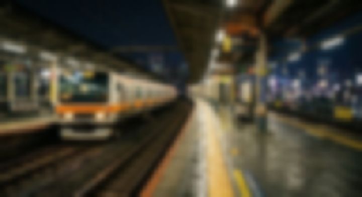 夜の駅ホームに停車するオレンジ色の電車