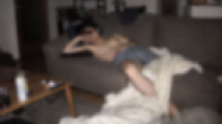 リビングのソファで毛布をはだけて眠る上半身裸の男性