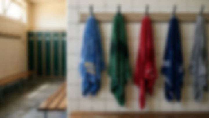 色違いのタオルが壁に掛かったタイル張りのロッカールーム